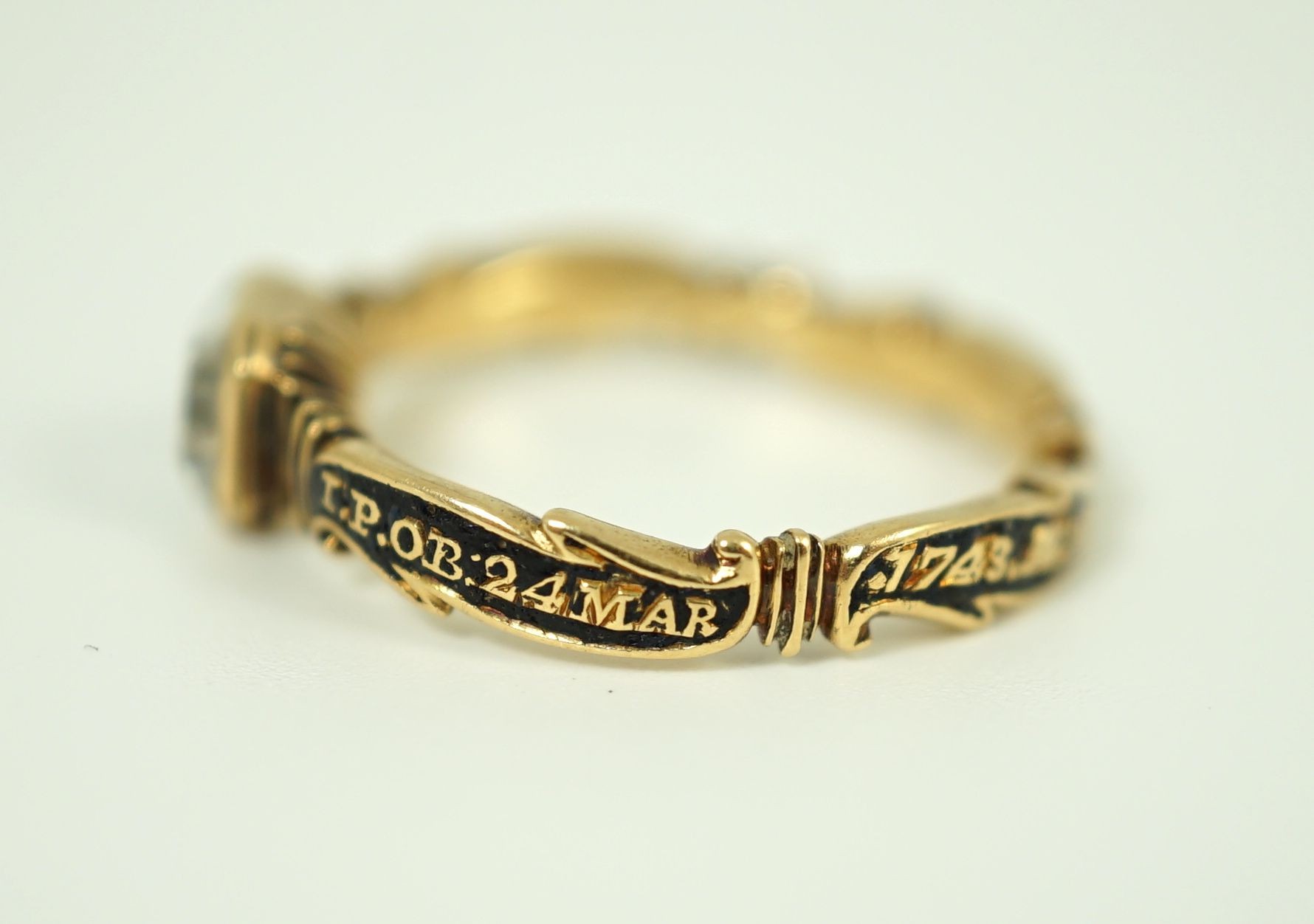 A George II gold, black enamel and rock crystal set mourning ring